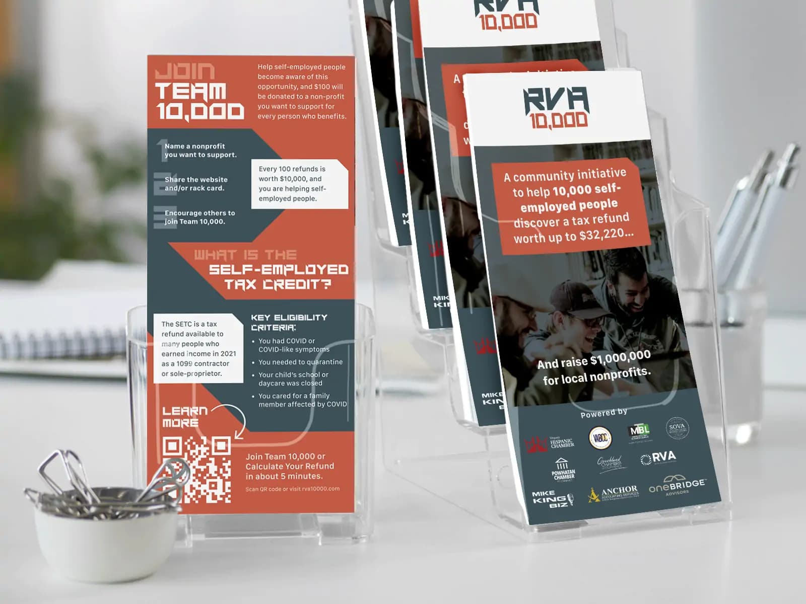 Rack cards for RVA 10,000, displaying both front and back in racks on a table. Front of card features logo, photo of people smiling and working together, and logos of various businesses and chambers of commerce in a "Sponsored by" section. The front reads, "A community initiative to help 10,000 self-employed people discover a tax refund worth up to $32,220… And raise $1,000,000 for local nonprofits." The back has a geometrical design to divide content, using the RVA 10,000 color palette. It reads, "Join Team 10,000. Help self-employed people become aware of this opportunity, and $100 will be donated to a nonprofit you want to support for every person who benefits. 1. Name a nonprofit you want to support. 2. Share the website and/or rack card. 3. Encourage others to join Team 10,000. Every 100 refunds is worth $10,000, and you are helping self-employed people. What is the Self-employed Tax Credit? The SETC is a tax refund available to many people who earned income in 2021 as a 1099 contractor or sole-proprieter. Key Eligibility Criteria: • You had COVID or COVID-like symptoms. • You needed to quarantine. • Your child's school or daycare was closed. • You cared for a family member affected by COVID. Join Team 10,000 or Calculate Your Refund in 5 minutes. Scan QR code or visit rva10000.com."